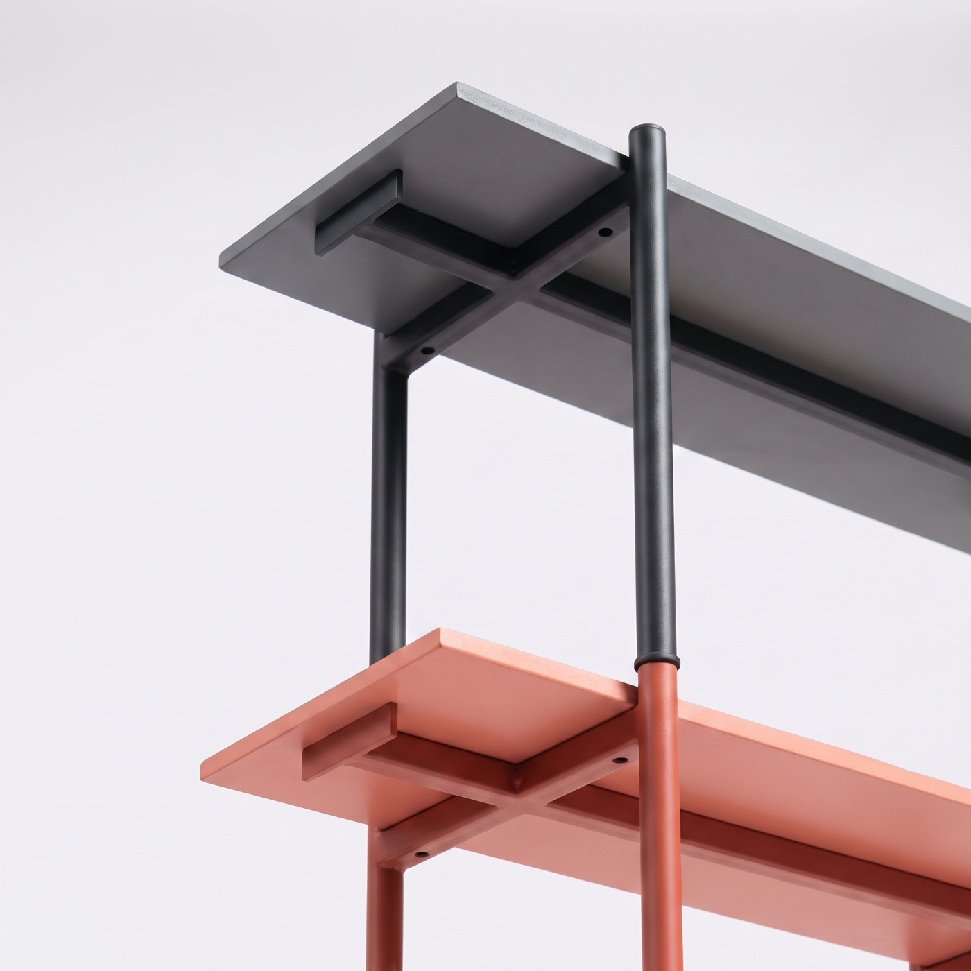The underside of a Charcoal board and a Coral board, with the steel bracket under each and a Charcoal post stacked into a Coral one